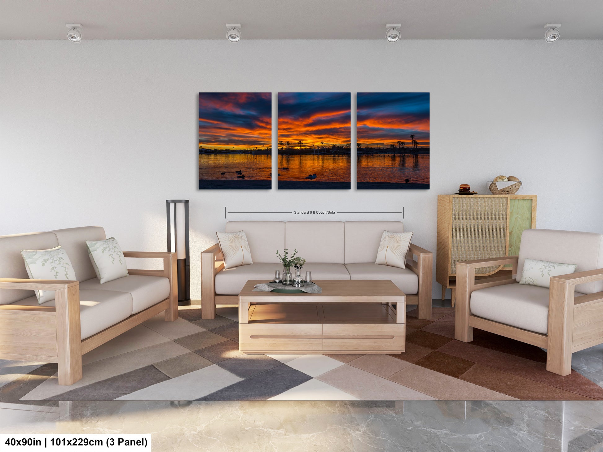The image is a modern living room with a large, three-panel landscape painting hanging on the wall. The painting depicts a serene sunset over a body of water, with the sky filled with vibrant colors. The room is furnished with a sofa, two chairs, and a coffee table, creating a comfortable and inviting atmosphere.
