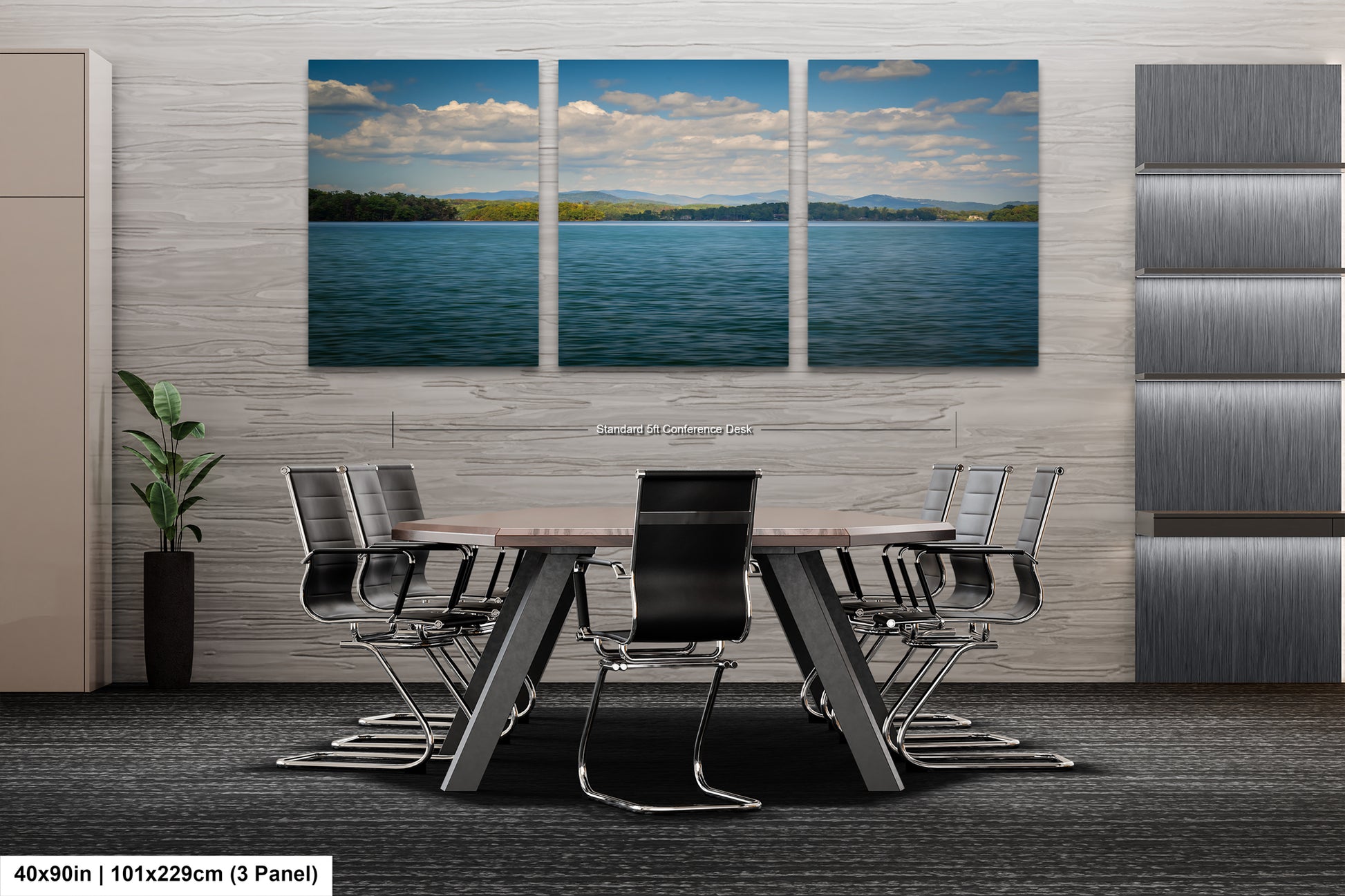 A modern office space with a large wall-mounted painting depicting a serene landscape of a lake and mountains. The painting is divided into three panels, creating a sense of depth and perspective. The office features a wooden table surrounded by black chairs, and a plant in a vase is placed on the floor. The image is described as a collage of multiple images, and the dimensions provided are 40.9in by 101.29cm by 3 panels.