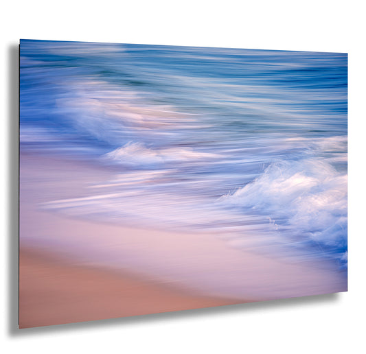 a blurry photo of a beach with a wave coming in