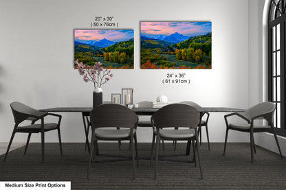 a dining table with four chairs and a vase with flowers