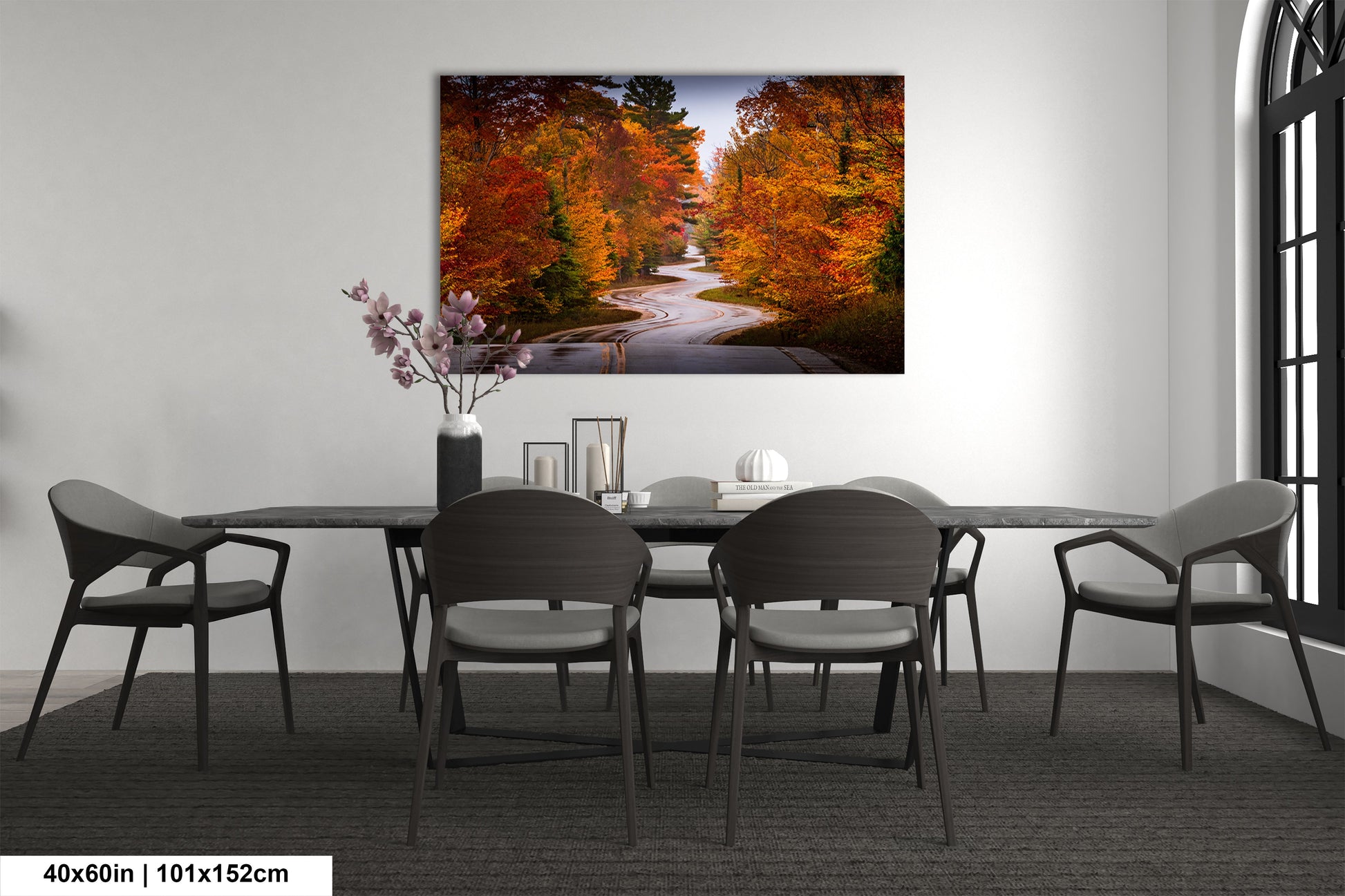 a dining room table with chairs and a painting on the wall
