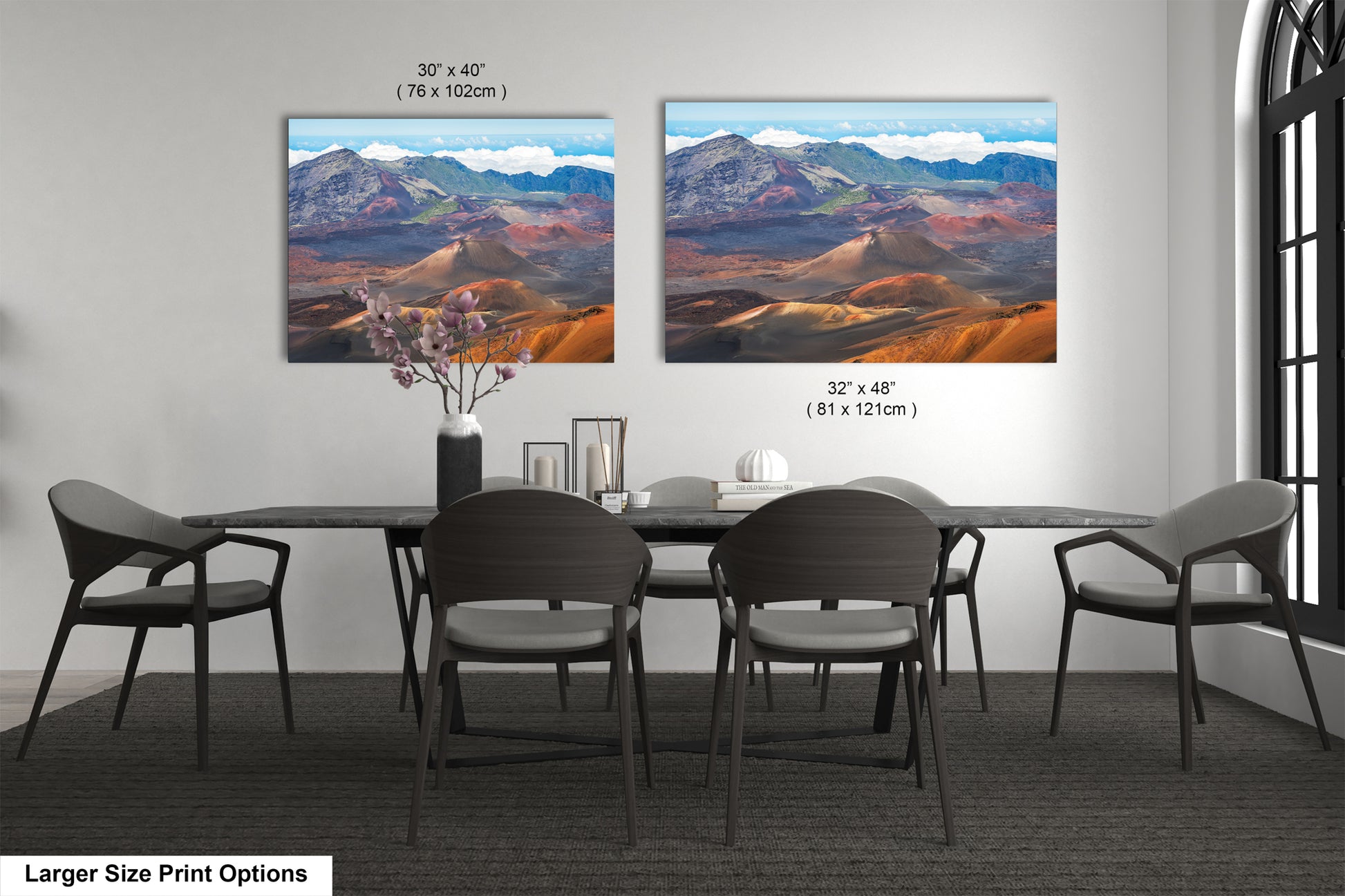 two large landscape paintings hanging on a wall above a dining table with chairs.