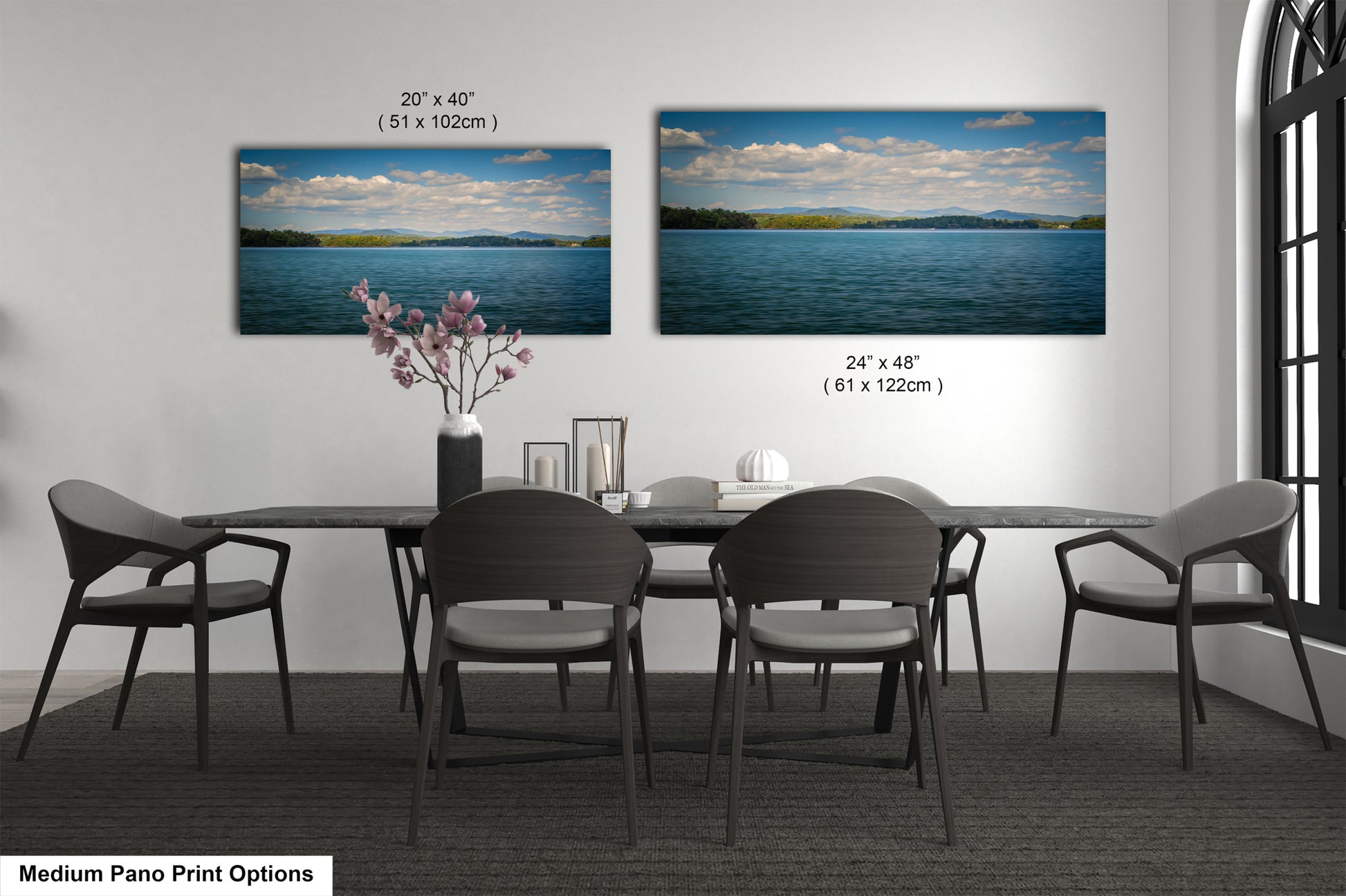 a modern dining room with a large painting of a serene lake and mountains hanging on the wall above a black table with four chairs.