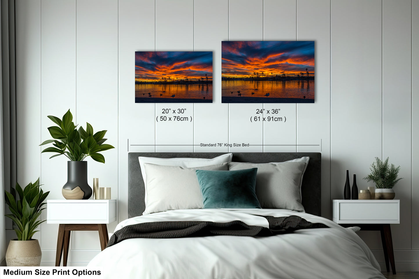 a bedroom with a bed, nightstands, and potted plants. There are two framed landscape photographs hanging on the wall above the bed, depicting a sunset over a body of water. The photographs are of medium size, with dimensions of 20 x 30" (50 x 70") and 24 x 36" (61 x 91") in inches.