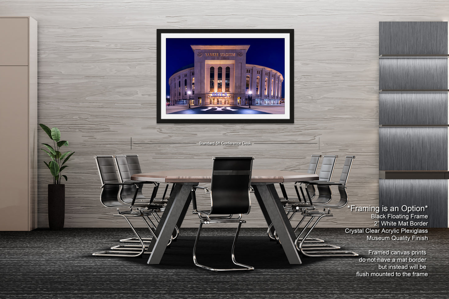 a modern office space with a large framed photograph of a building on the wall, a wooden table surrounded by black chairs, and a plant in a black vase on the floor.