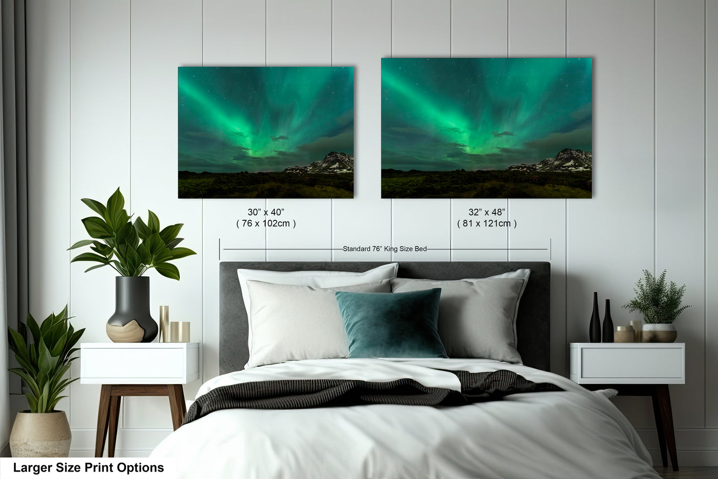 a bed with two pictures of the northern lights above it