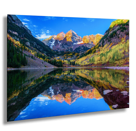 a mountain range is reflected in the still water of a lake