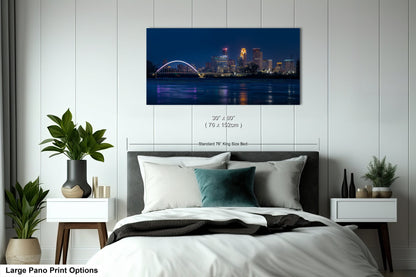 a bedroom with a large bed and a night view of a city
