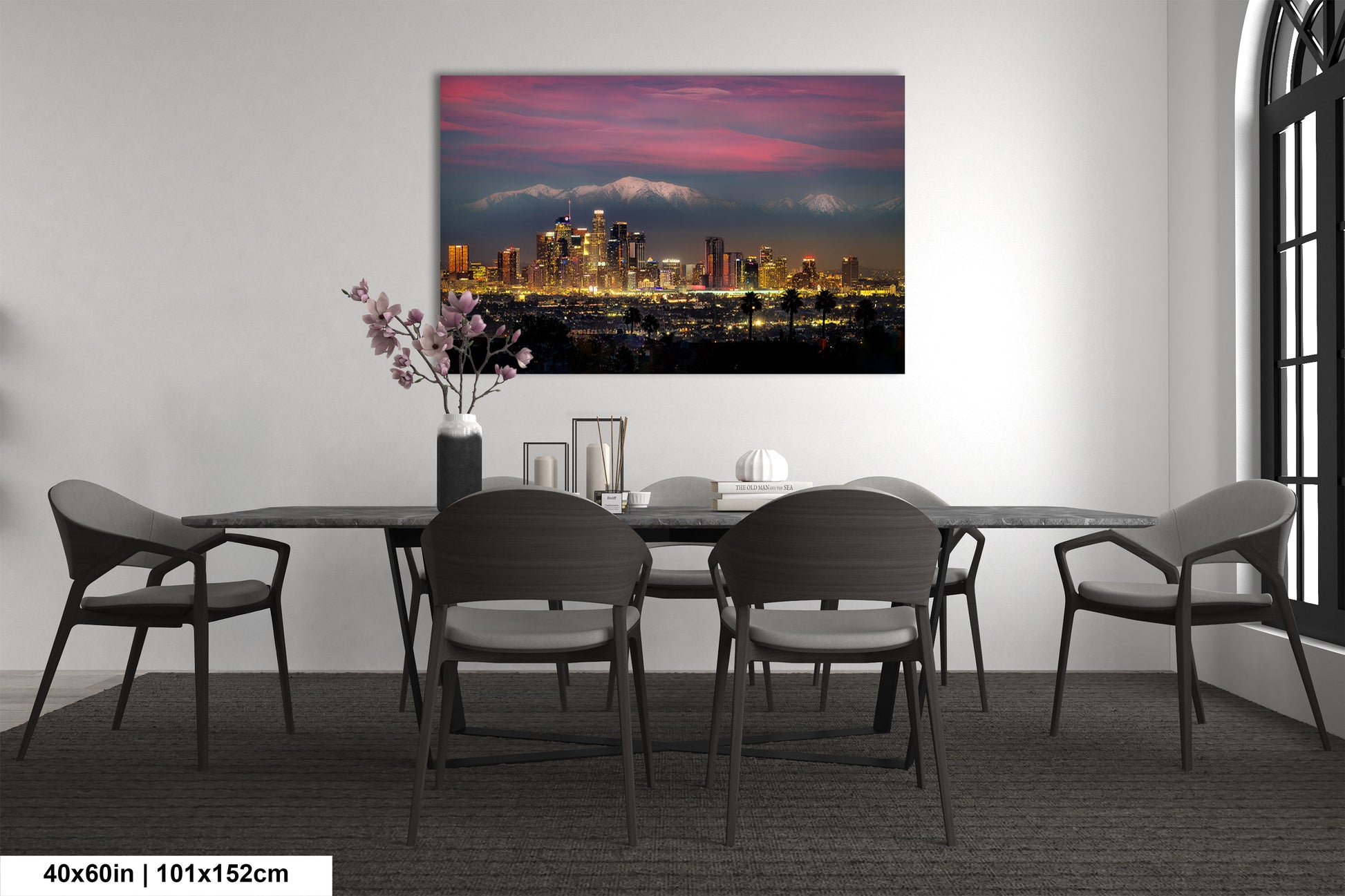 a dining room table with chairs and a painting on the wall