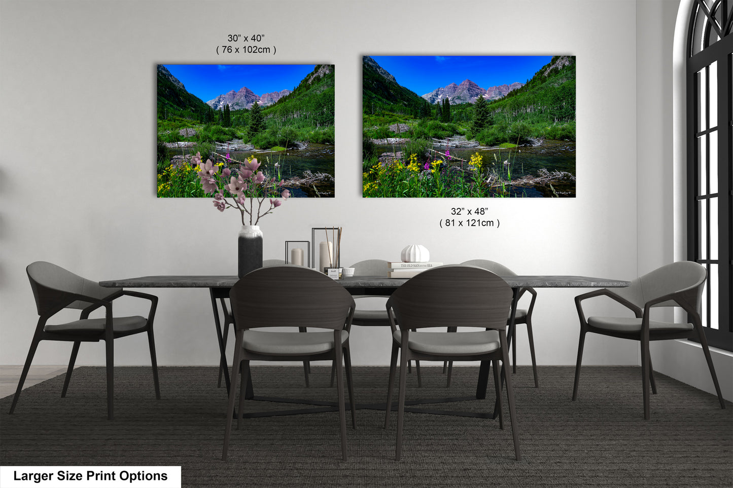 a dining table with four chairs and a vase of flowers