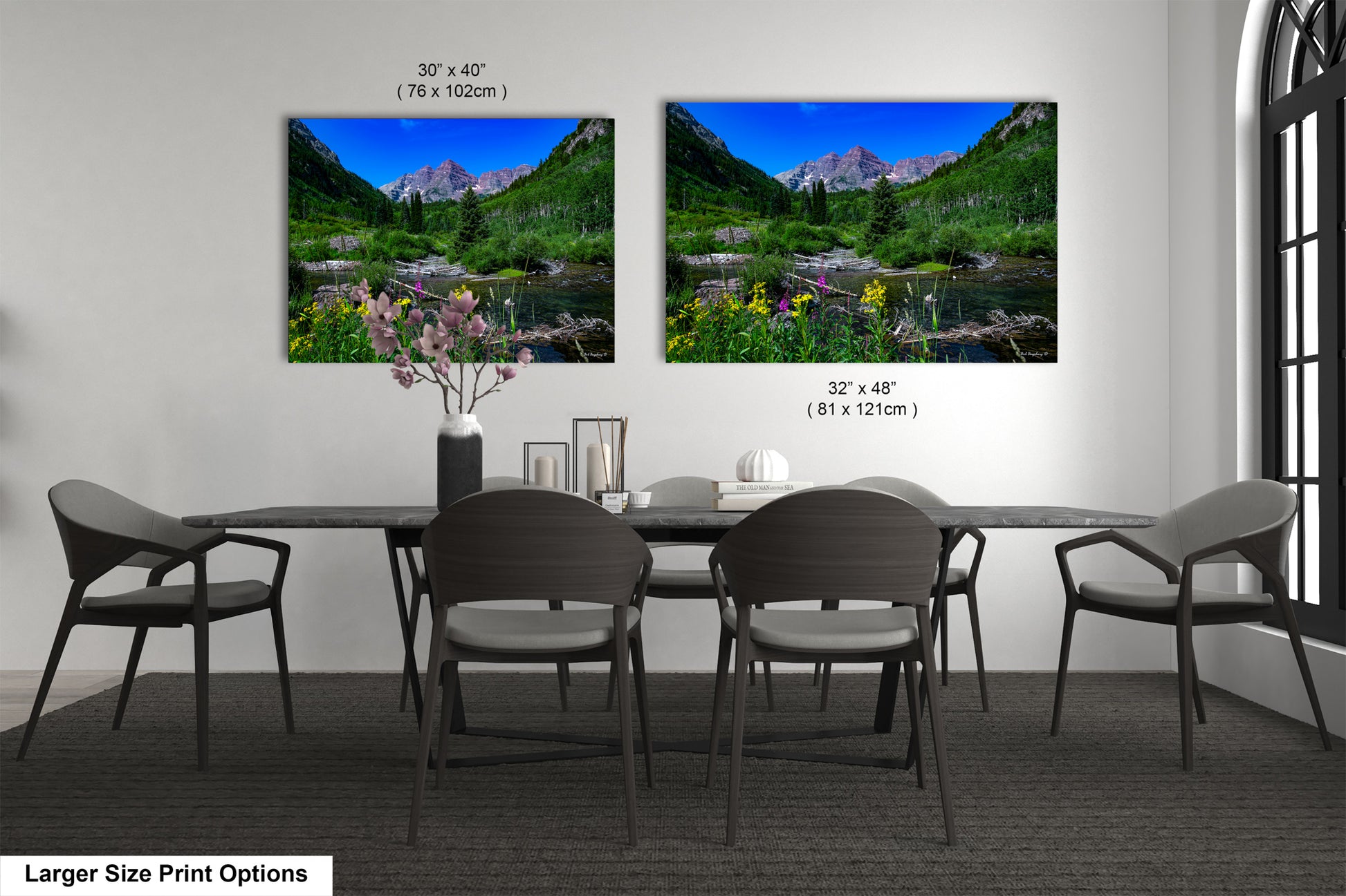 a dining table with four chairs and a vase of flowers