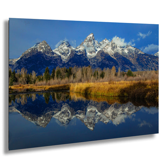 a mountain range is reflected in the still water of a lake