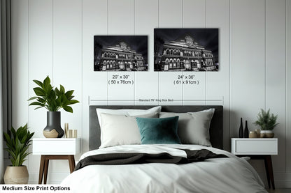 a bed with a white comforter and two black and white pictures on the wall