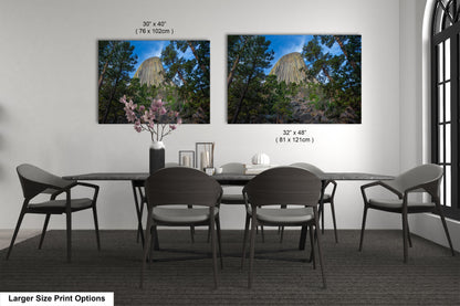 a dining table with four chairs and a vase of flowers