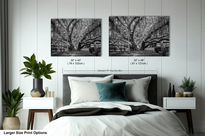 a bed with a white comforter and two black and white pictures on the wall