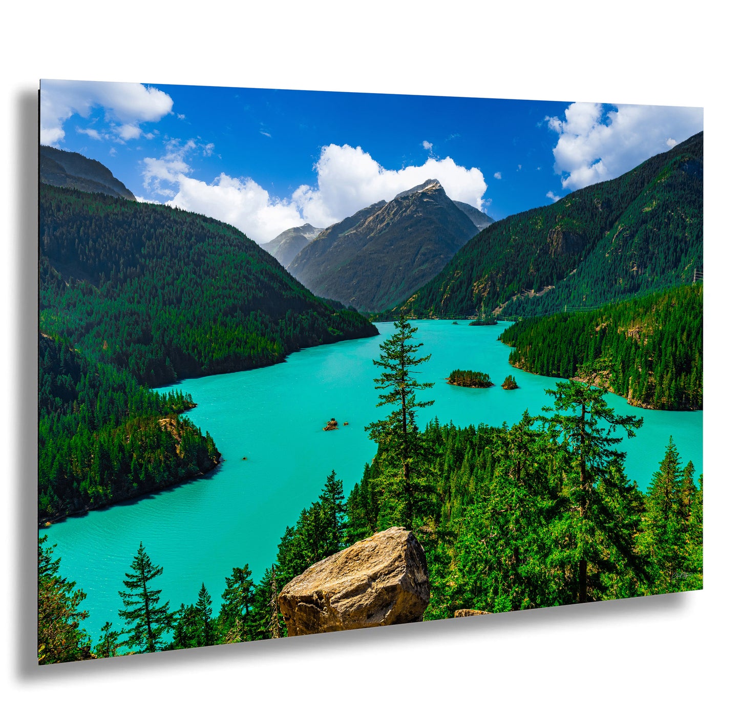 a stunning natural landscape with a turquoise lake surrounded by lush green forests and towering mountains in the background.