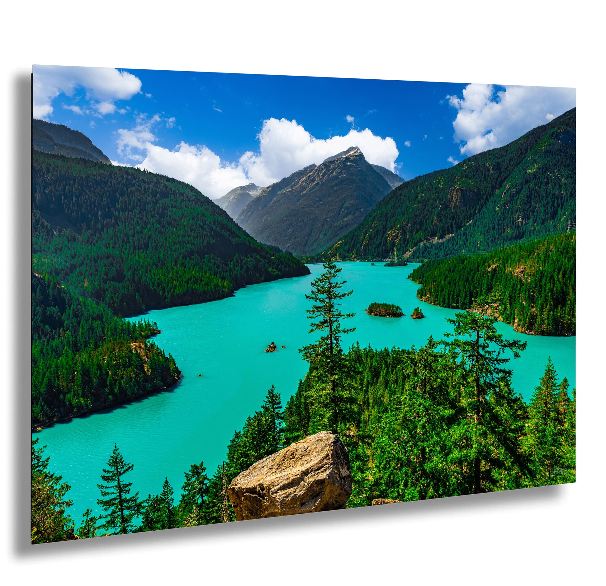 a stunning natural landscape with a turquoise lake surrounded by lush green forests and towering mountains in the background.