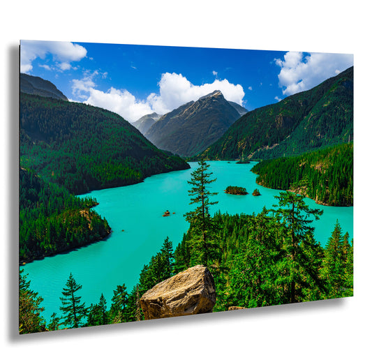 a stunning natural landscape with a turquoise lake surrounded by lush green forests and towering mountains in the background.
