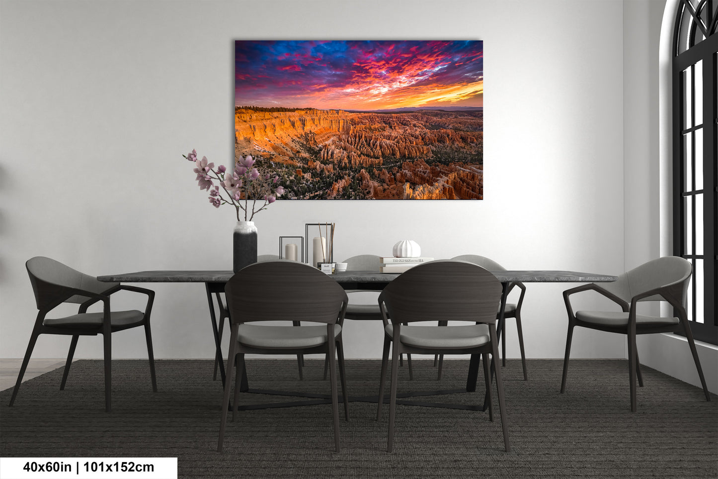 a dining room table with chairs and a painting on the wall