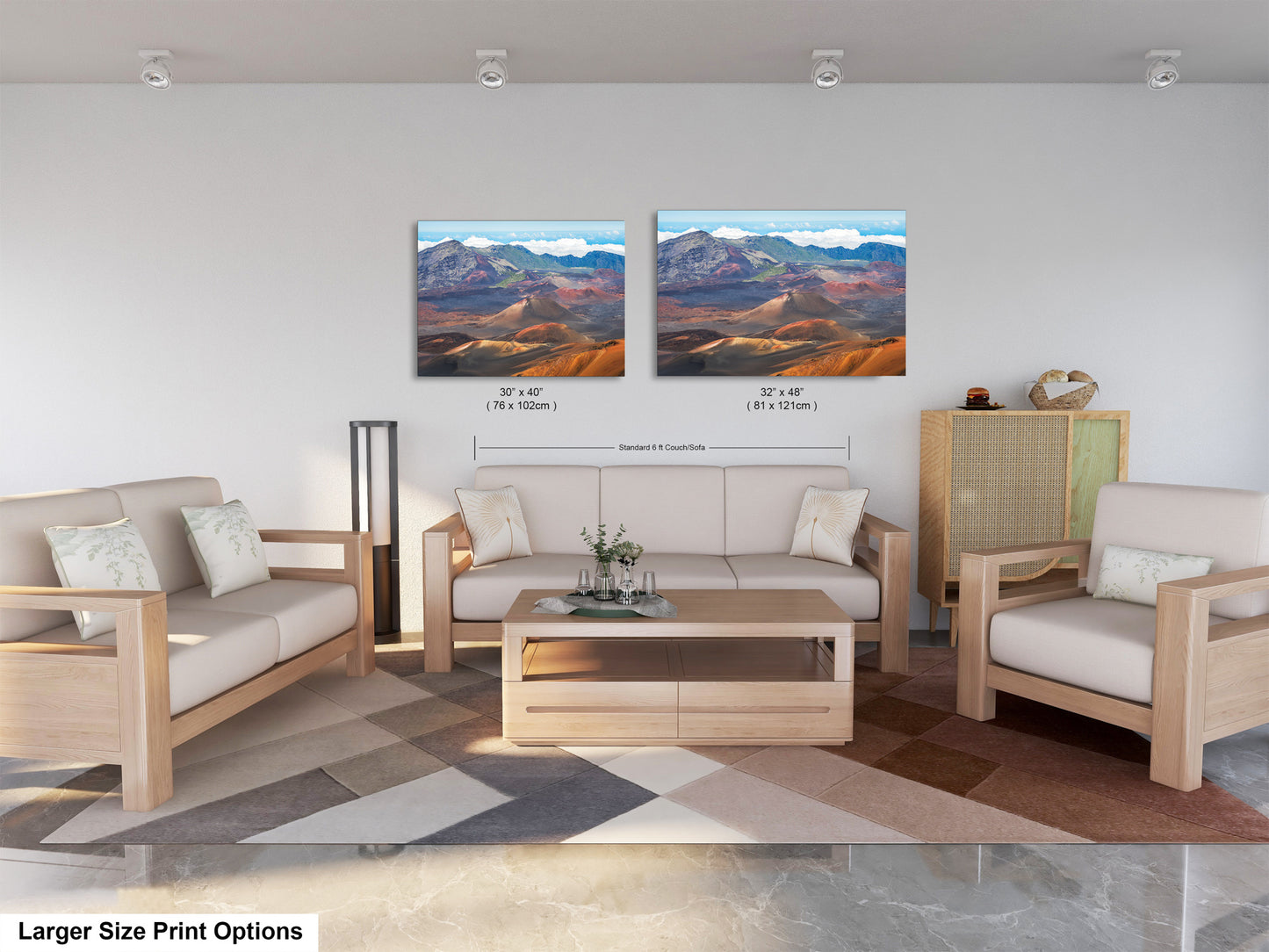 a modern living room with a large sofa, two chairs, and a coffee table. There are two framed landscape paintings hanging on the wall above the seating area.