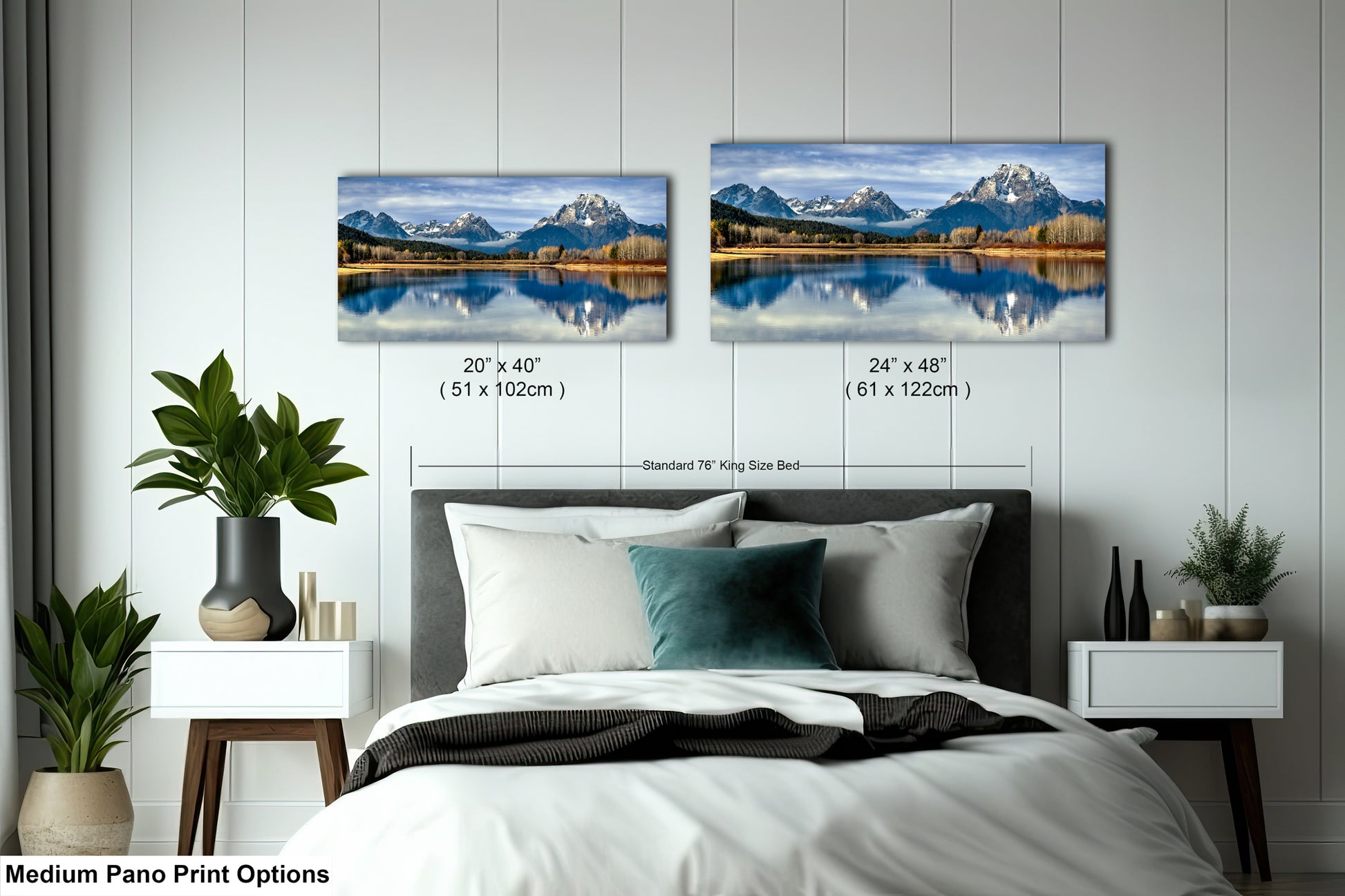 a bedroom with a bed and nightstands, along with two framed landscape photographs hanging on the wall. The photographs depict a serene mountain lake scene, with the mountains reflected in the calm waters. The bed has a white comforter and a blue throw pillow. The wall is painted white, and there are potted plants and other decorative items in the room.