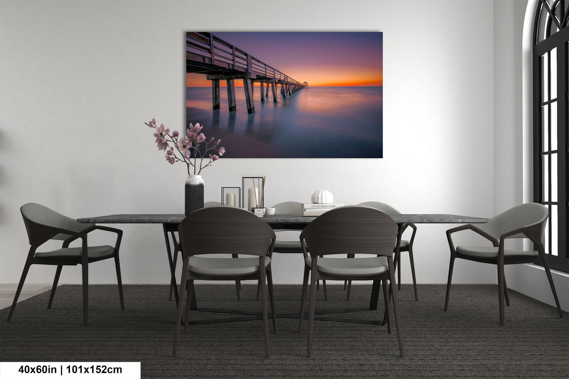 a dining room table with chairs and a painting on the wall