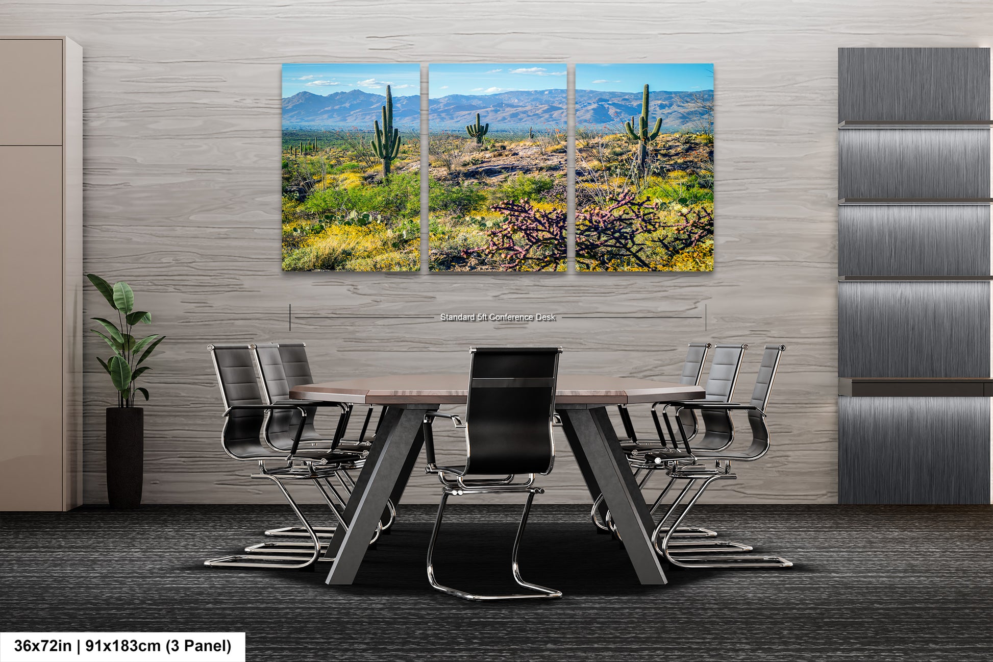 A modern office space with a large, three-panel landscape painting depicting a desert scene with cacti and mountains in the background. The painting is mounted on a gray wall above a wooden table surrounded by black chairs.