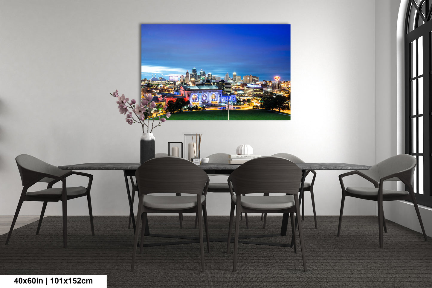a dining room table with chairs and a painting on the wall