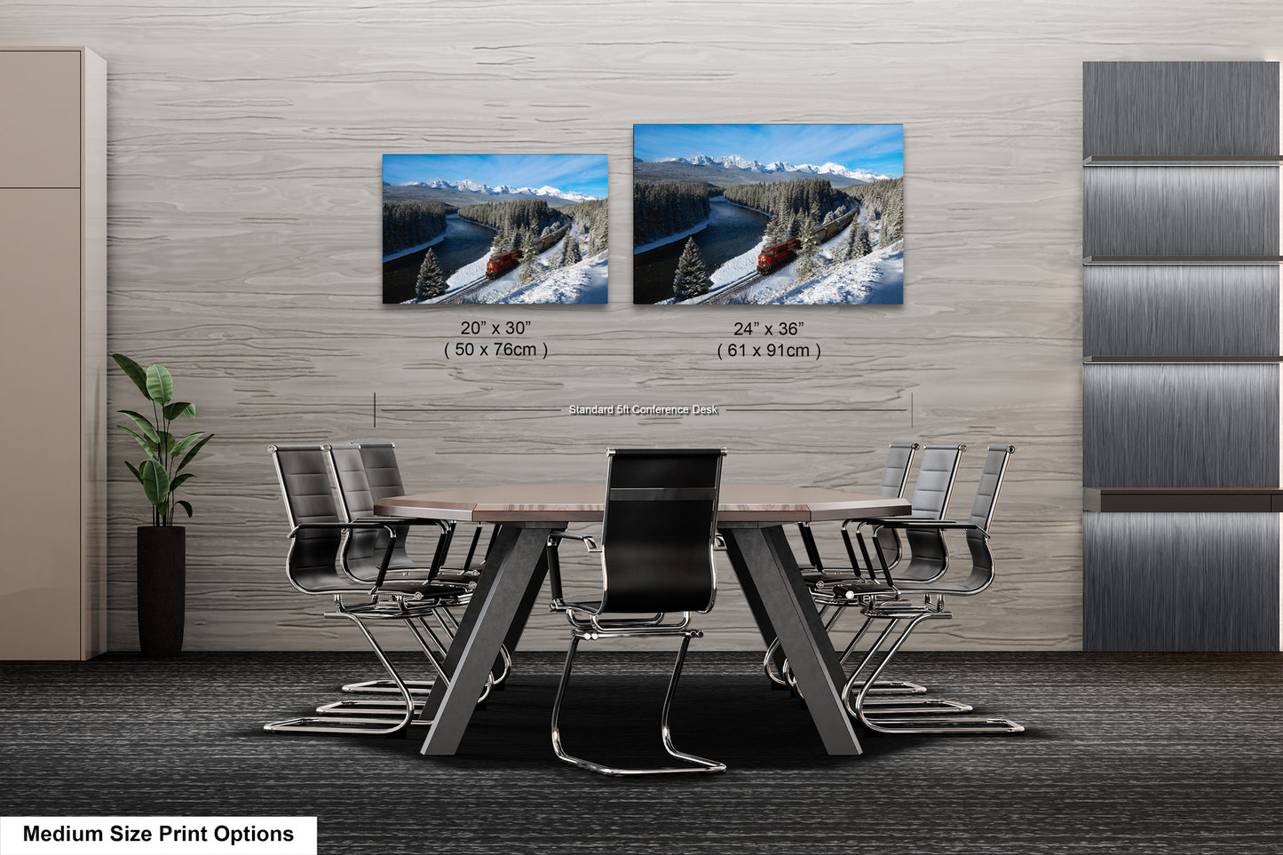 a modern office space with a large wooden table surrounded by black chairs. Two framed landscape photographs are displayed on the wall above the table, depicting snowy mountain scenery. The text indicates that the medium size print options include the two framed photographs.