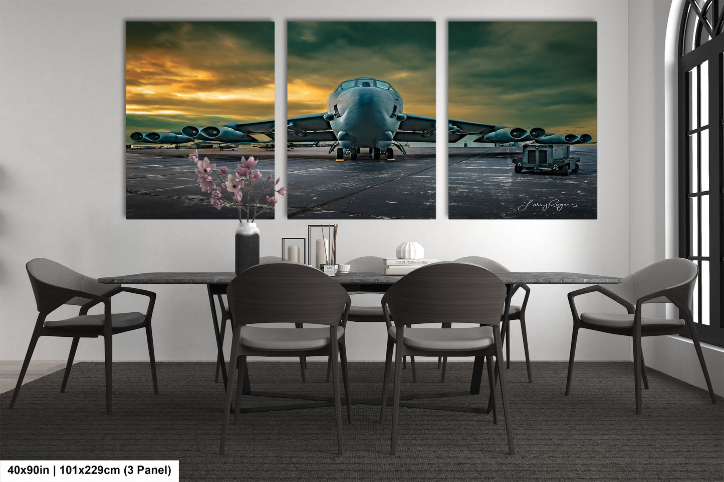 a dining room table with four chairs and three paintings of a plane