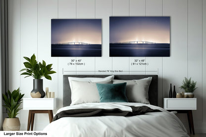 a bed with two pictures of a bridge on the wall above it