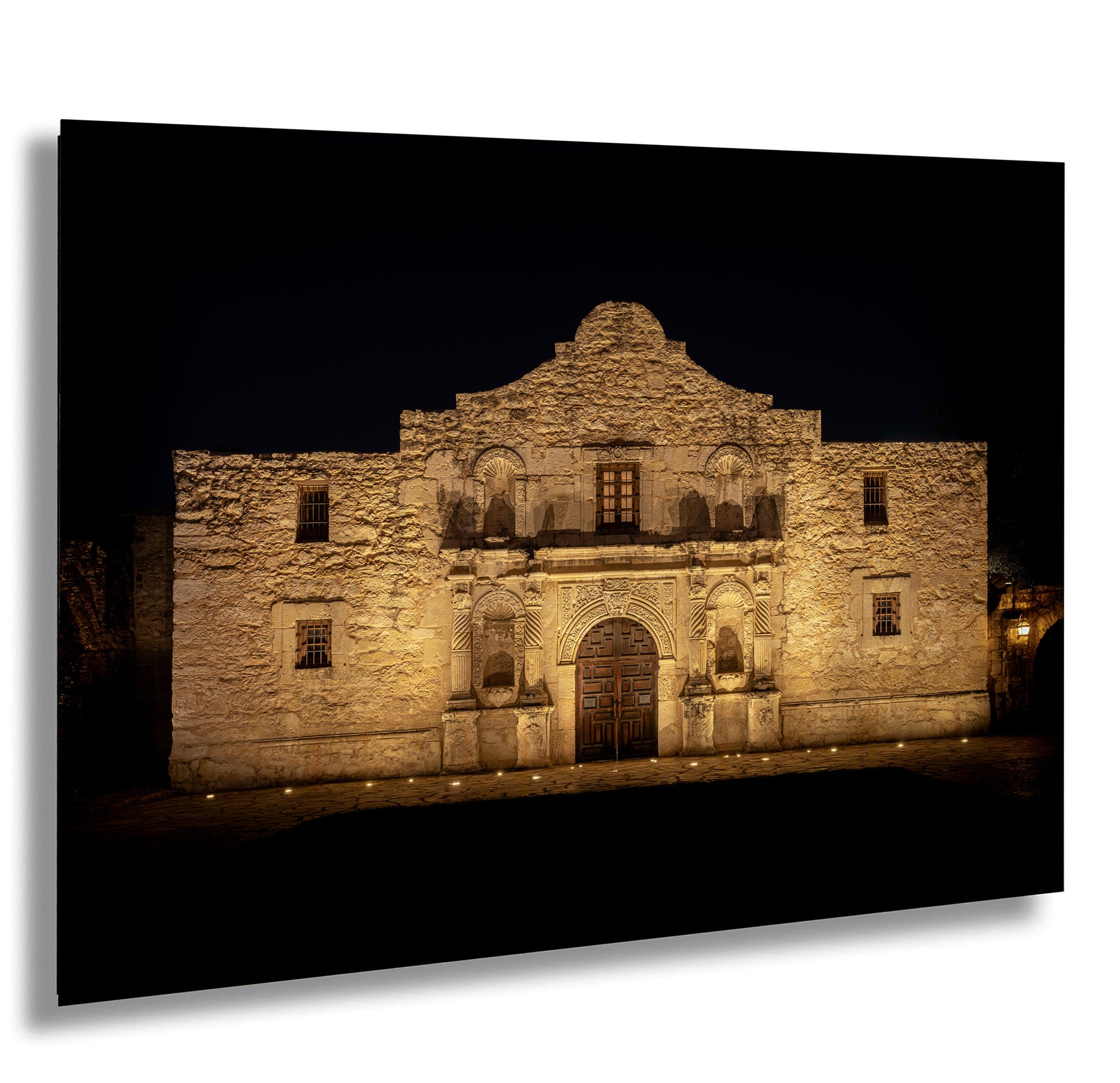 A large, ornate building with a distinctive architectural style, illuminated at night.