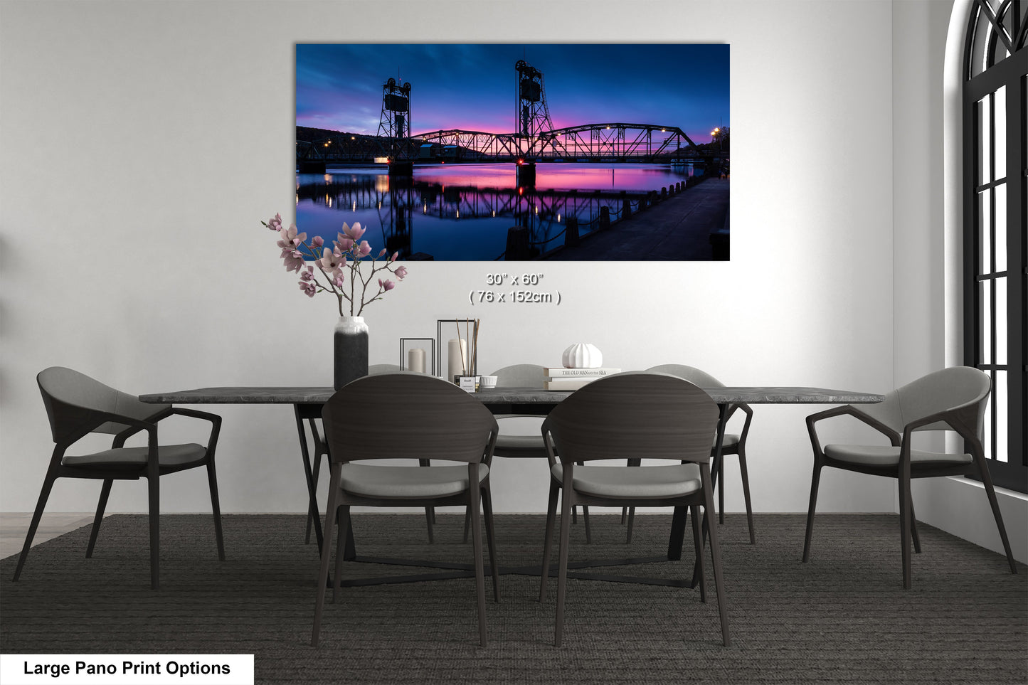 a dining room table with chairs and a painting on the wall