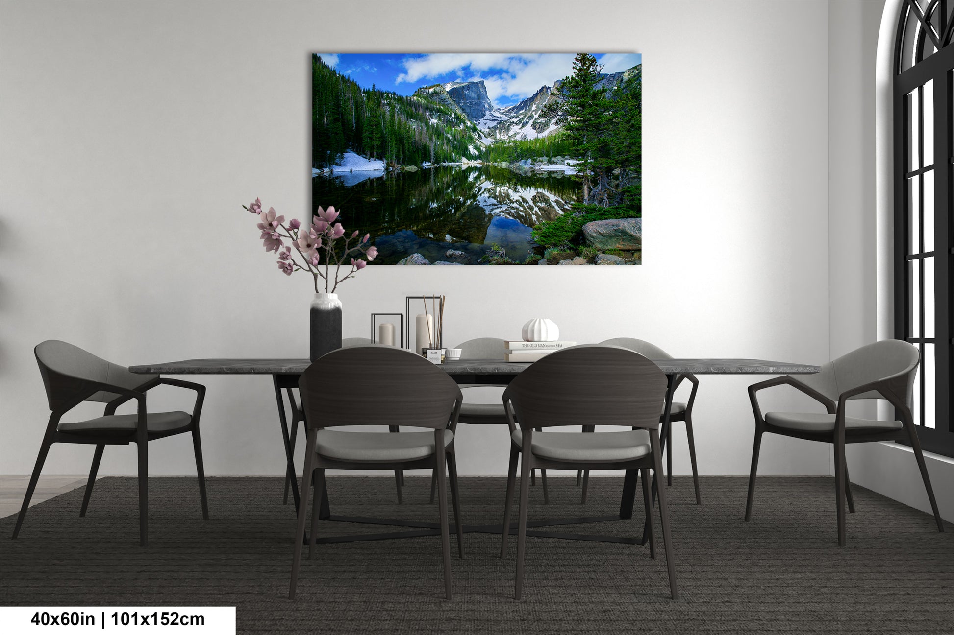 a dining room table with chairs and a painting on the wall