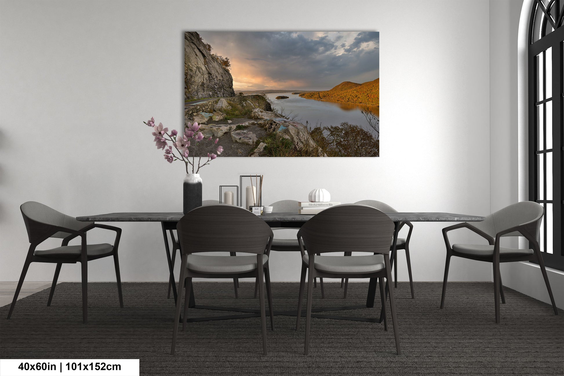 a dining room table with chairs and a painting on the wall