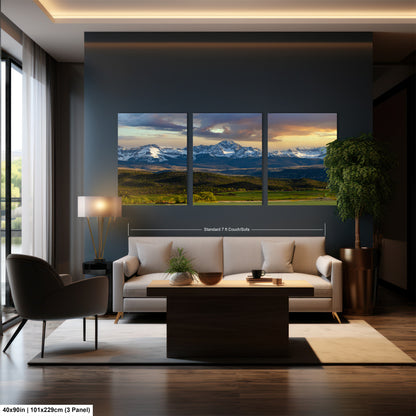 a modern living room with a large, three-panel landscape painting of a mountain range in the background. The painting is mounted on the wall above a white sofa and a coffee table.