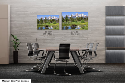 a dining room table with chairs next to a wall with pictures of mountains