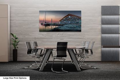 a modern living room with a large painting of a harbor scene hanging on the wall. The room is furnished with a sofa, two chairs, and a coffee table, creating a comfortable and inviting atmosphere.