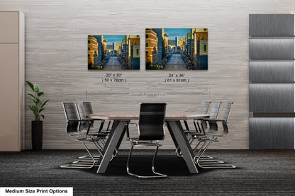 a dining room table with chairs and two pictures on the wall