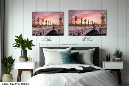 a bed with a white comforter and two pictures of a bridge