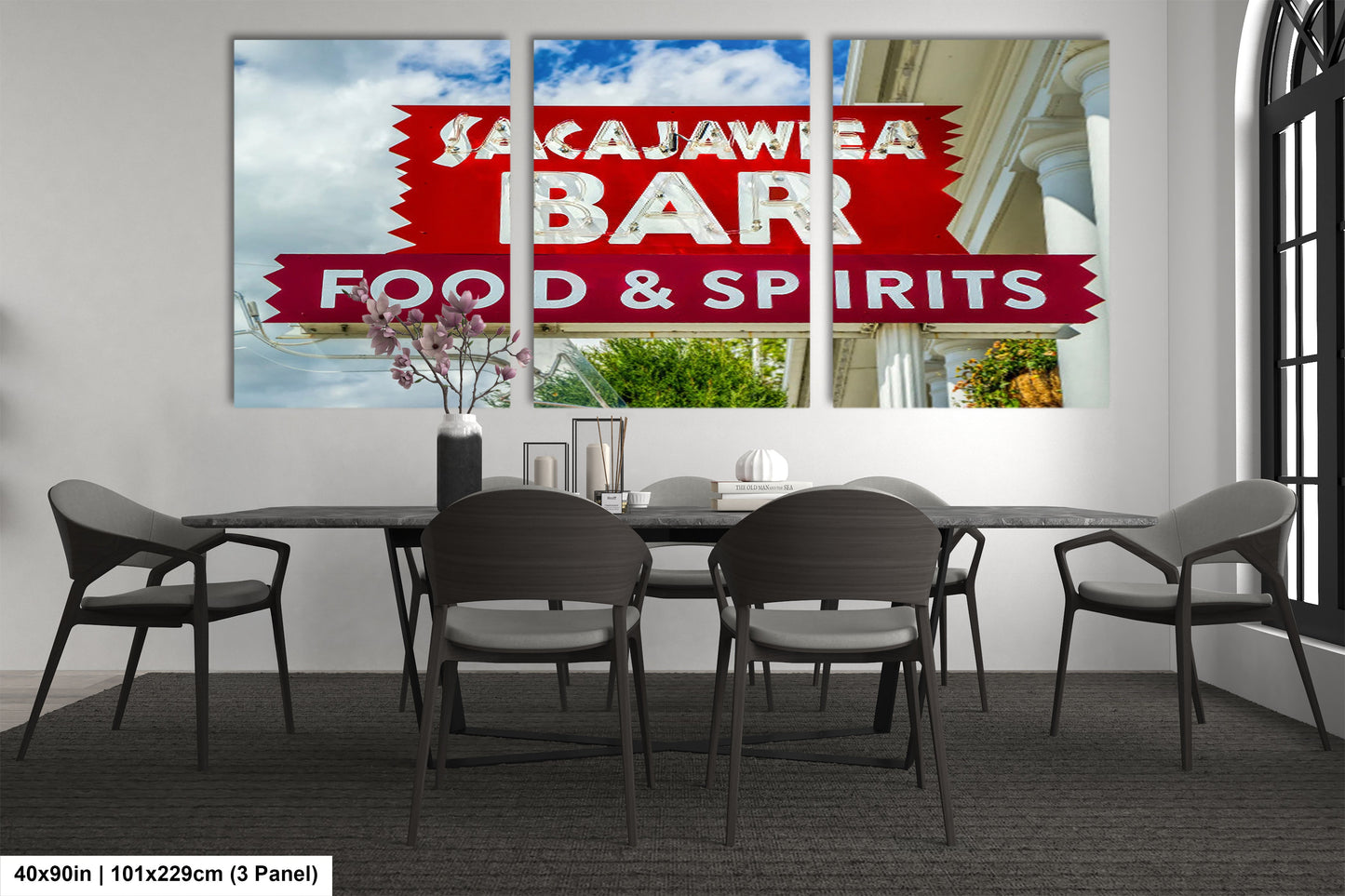 a dining room table with chairs and a sign on the wall