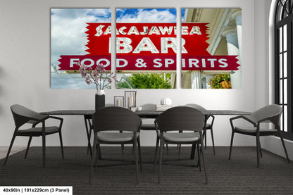 a dining room table with chairs and a sign on the wall