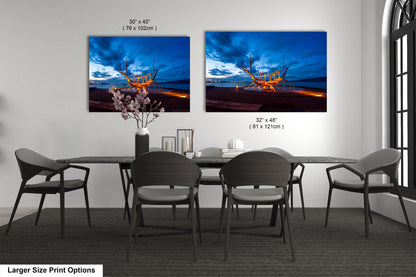 a dining room table with four chairs and two pictures on the wall