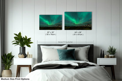 a bedroom with a bed and two pictures of the northern lights