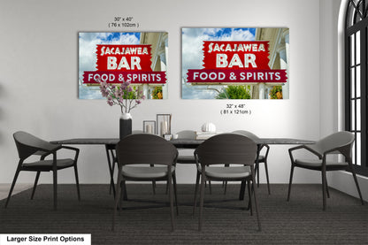 a dining room table with four chairs and two signs on the wall