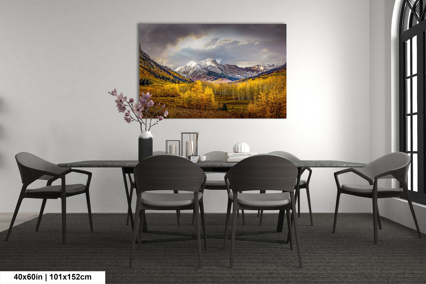 a dining room table with chairs and a painting on the wall