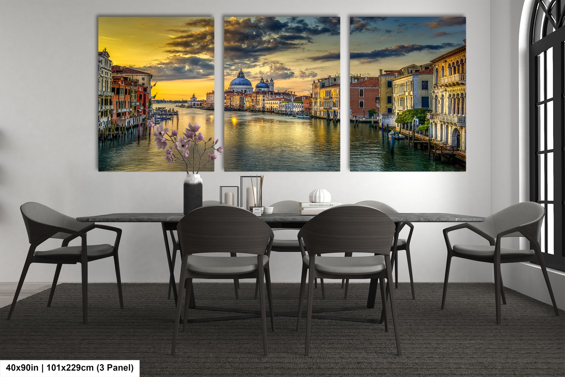 a dining room table with chairs and a painting on the wall