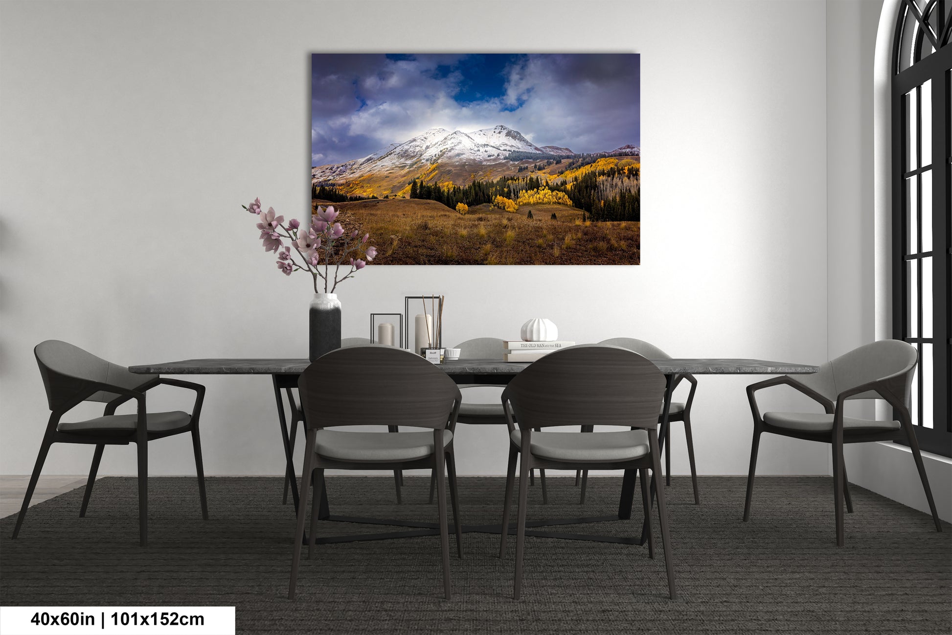 a dining room table with chairs and a painting on the wall