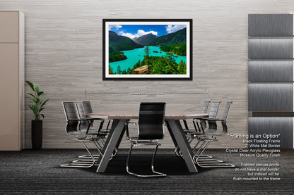 a modern office space with a large framed landscape painting hanging on the wall above a wooden table surrounded by black chairs.