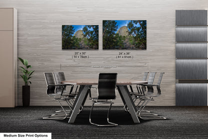 a dining room table with chairs and two pictures on the wall